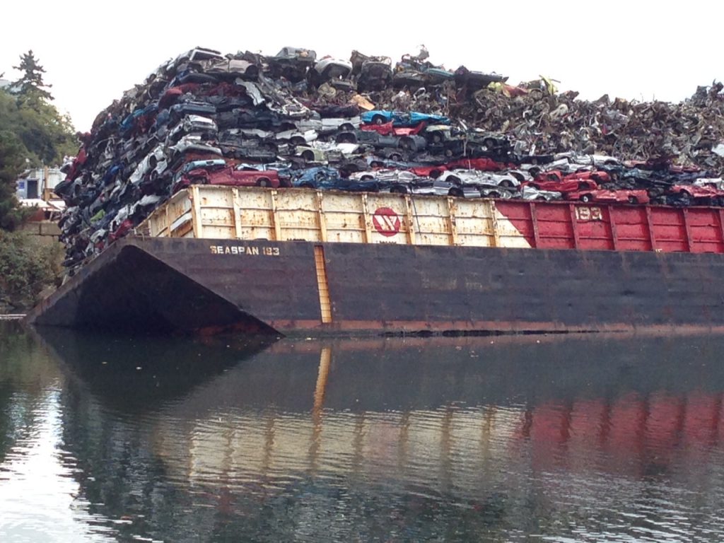 Scrap metal barge tips, dumping partial load into Victoria's Selkirk Waterway